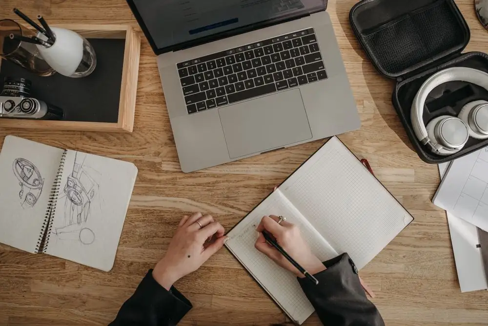 Minimalist desk setup with sketch notebooks, digital interface drafts, and design references